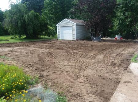 A white shed sitting in the middle of a dirt field.