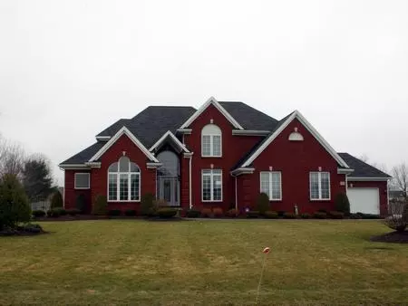 A large red house with a big lawn in front of it