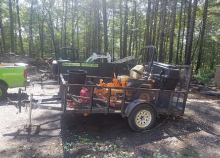 A trailer with many items in it and some trees