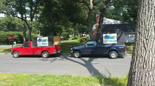 Two trucks parked on the side of a road.