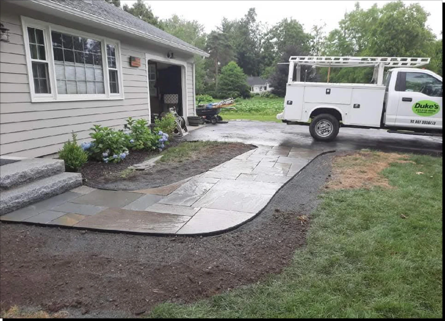 Stone pathway beside house and parked truck.