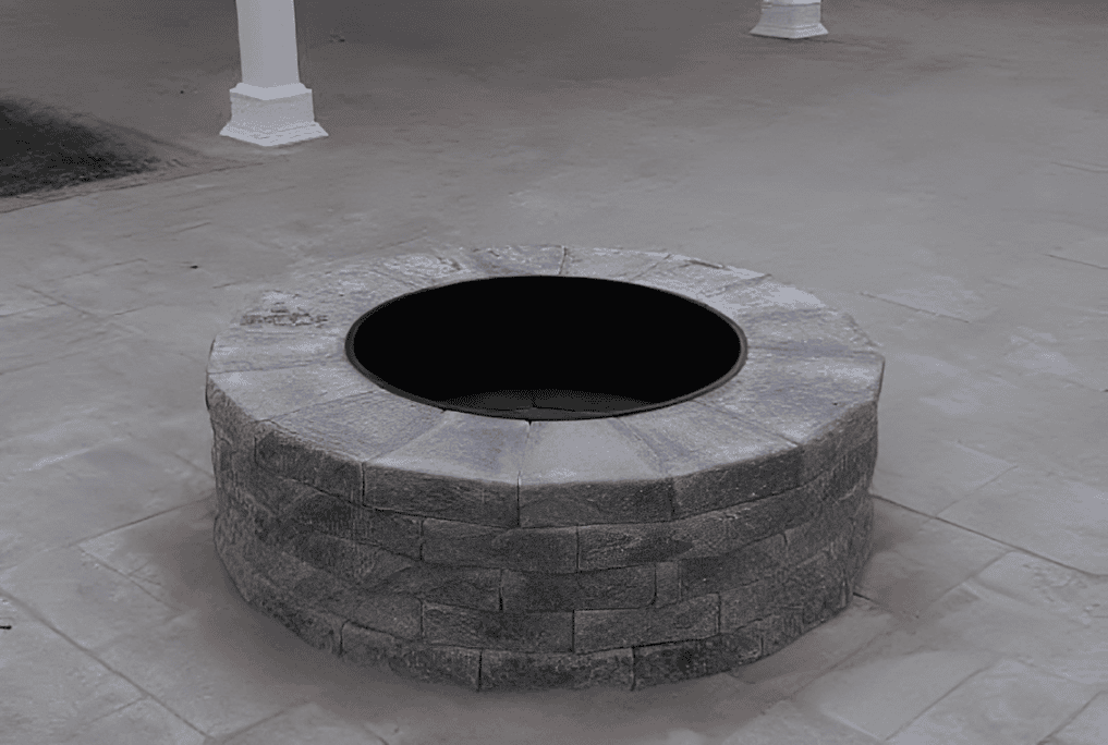 Stone well on a paved surface.