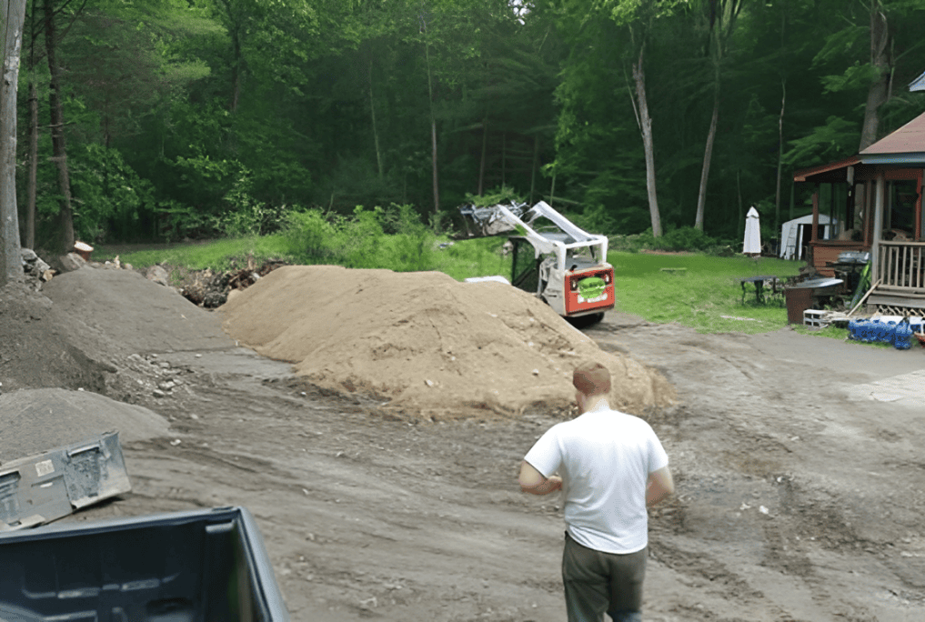 Man near construction site with dirt piles.
